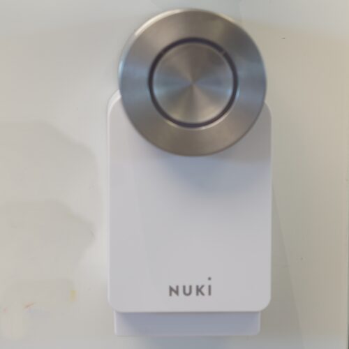 Das Nuki sitzt unter der Türklinke. Es besteht aus einer Mechanik, die über den Schlüssel am Türschloss angebracht wird.