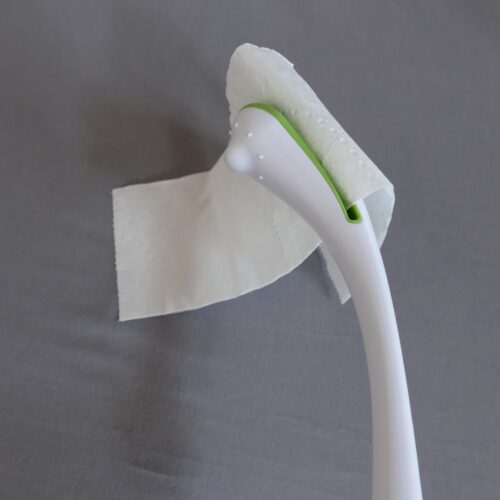 Weißer Stab, ergonomisch geformt, an einer Seite gespalten zum einschieben und einklemmen von Toilettenpapier. Griff verdickt.