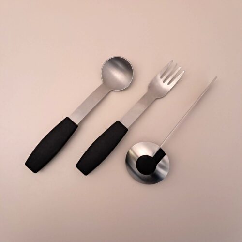 Setzt sich zusammen aus ergonomisch geformten Löffel, Gabel und Messer. Aus Metall, mit schwarzem Griff.