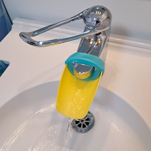 Gelbe Verlängerung des Wasserhahns um circa 10 cm mit Befestigung in aqua.
